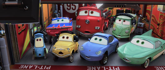 Luigi en jaune, Sally en bleu, Guido, Flo, Red, Fillmore et Ramone réunis dans un stand de course, tous l'air stupéfait